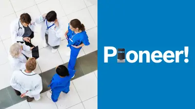 Six people are standing in a circle and talking. You can tell from their clothing that they are medical professionals. Four of the people are wearing a white coat; the other two are wearing blue trousers and blue gowns.